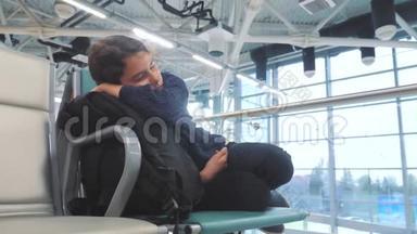 疲惫的少女少年旅行者睡在机场，等待飞机起飞，<strong>登机</strong>口的长椅上，充满了她的生活方式